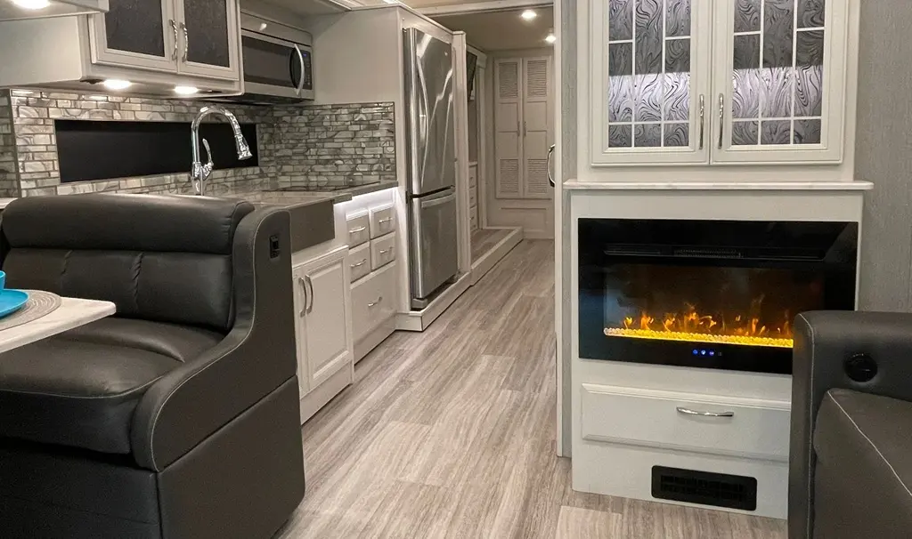 Luxury RV interior with full kitchen, living area, and fireplace—RV rentals in Florida Orlando.